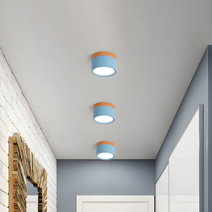 Blue cylindrical LED ceiling lights installed in a modern hallway ceiling
