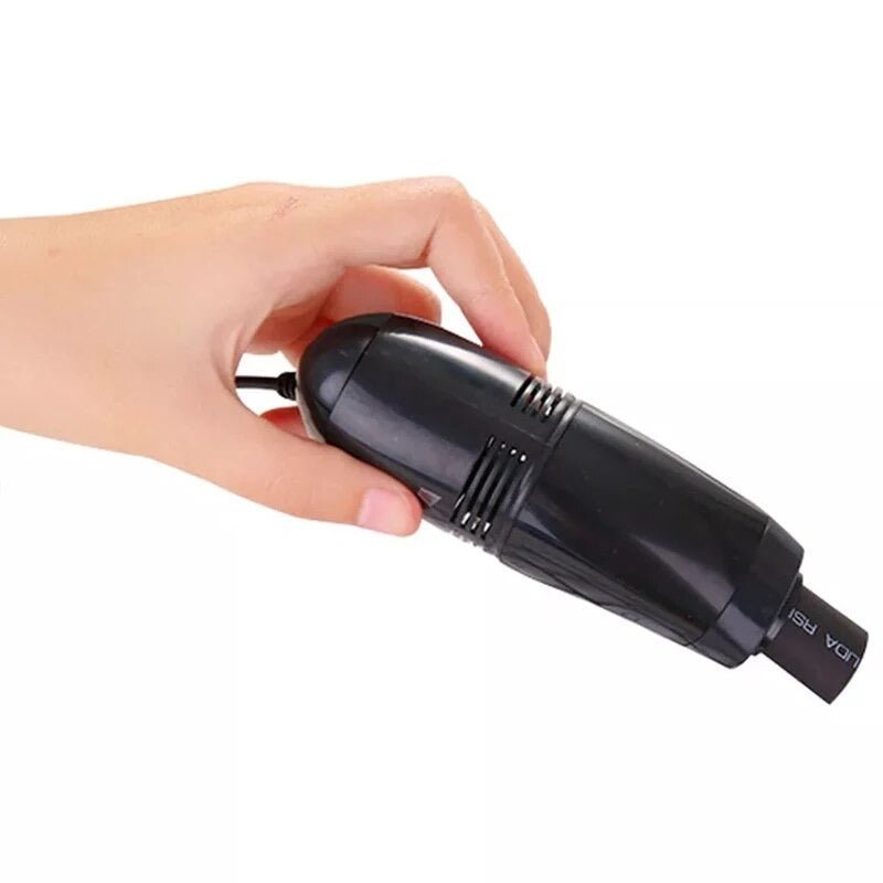 Hand holding compact black USB keyboard vacuum