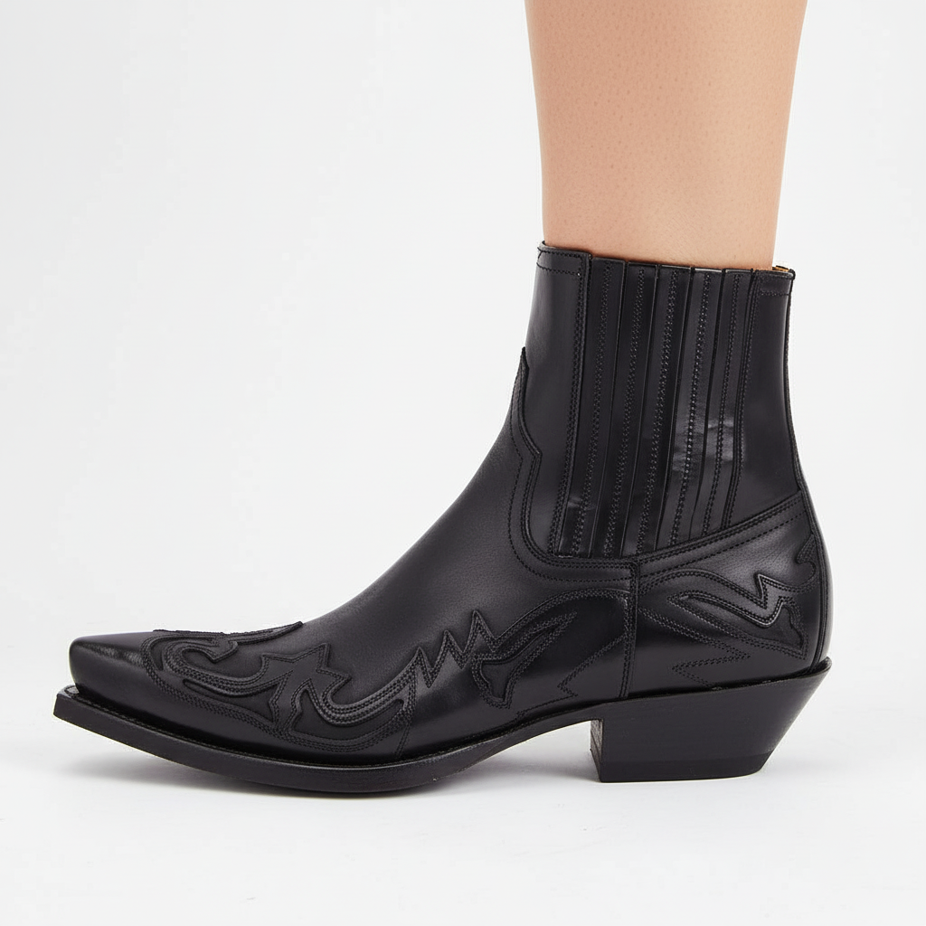 Side profile of a black embroidered western cowboy boot worn outdoors