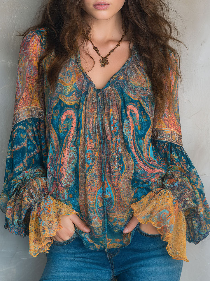 Woman wearing Cyrano flowy paisley blouse with ruffled cuffs and jeans