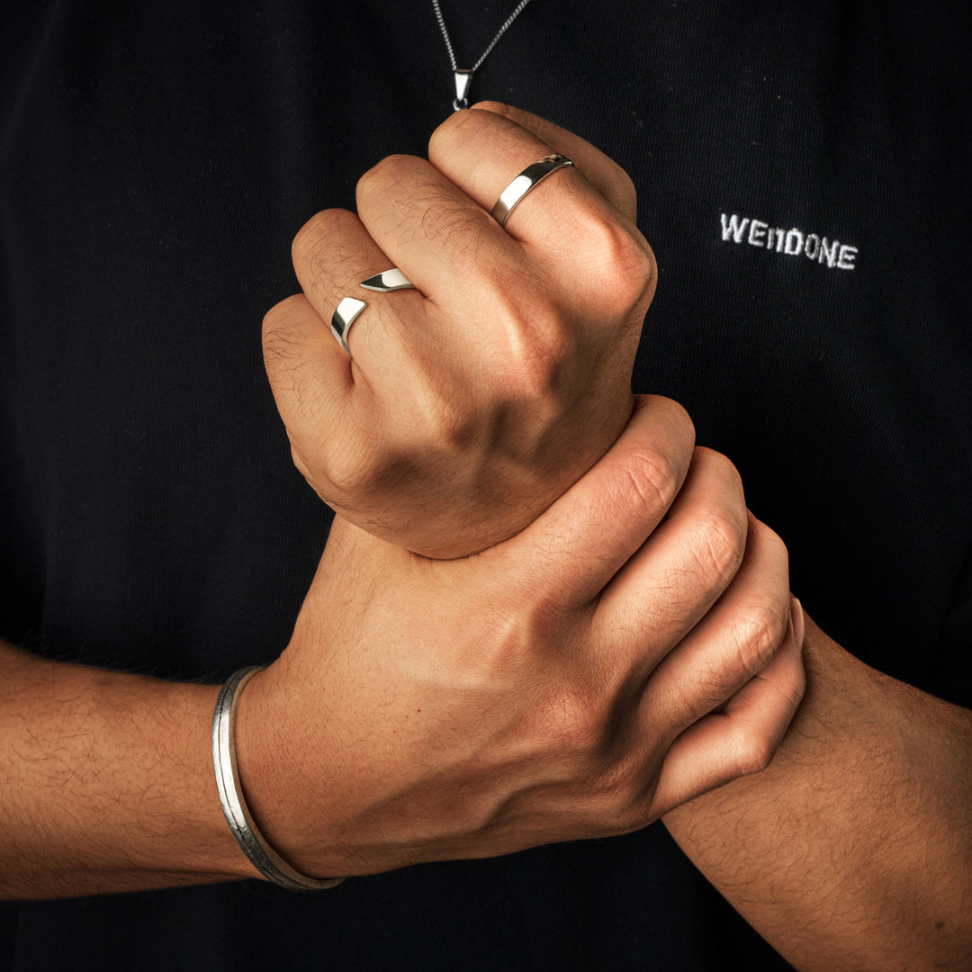Model wearing the Arvid Men's Open Band Ring on finger alongside other masculine accessories.