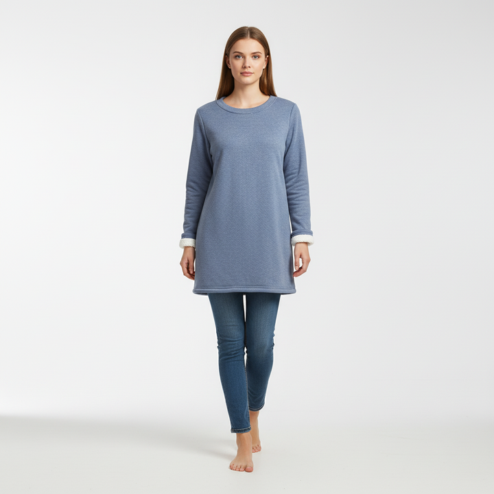 Full-body shot of a model wearing a blue fleece jumper and jeans against a white background