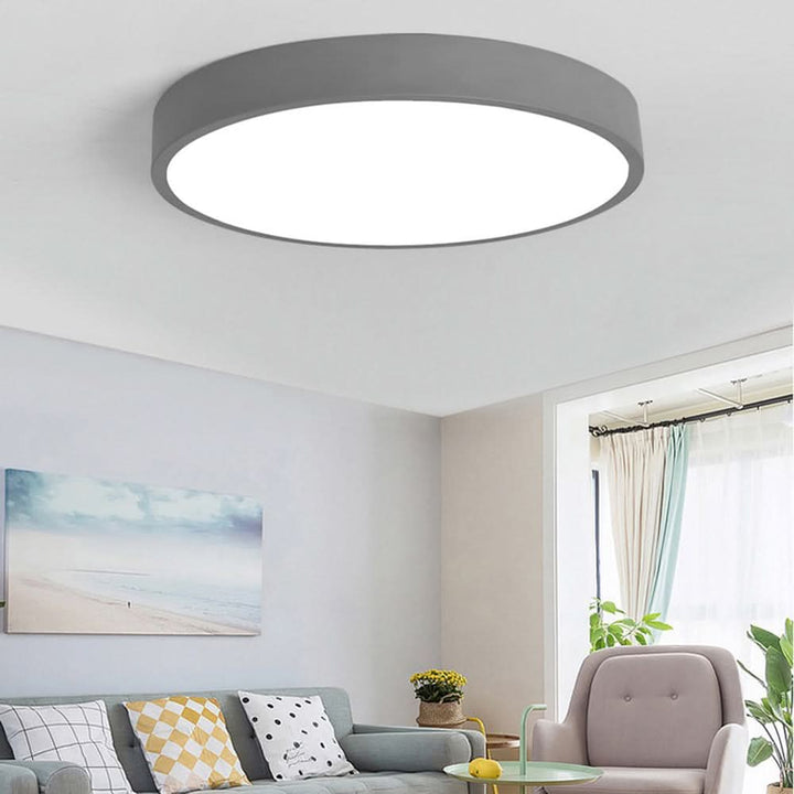 Modern round LED ceiling light fixture mounted on a clean white living room ceiling