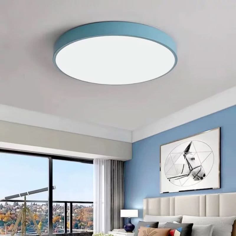 Modern blue round LED ceiling light installed in a stylish bedroom interior