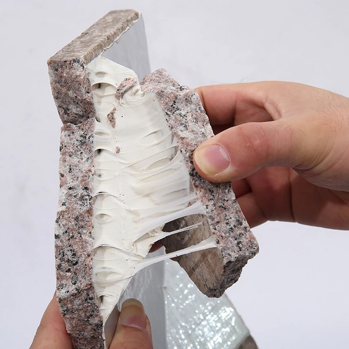 Close-up of heavy-duty adhesive tape stretching between two stone pieces