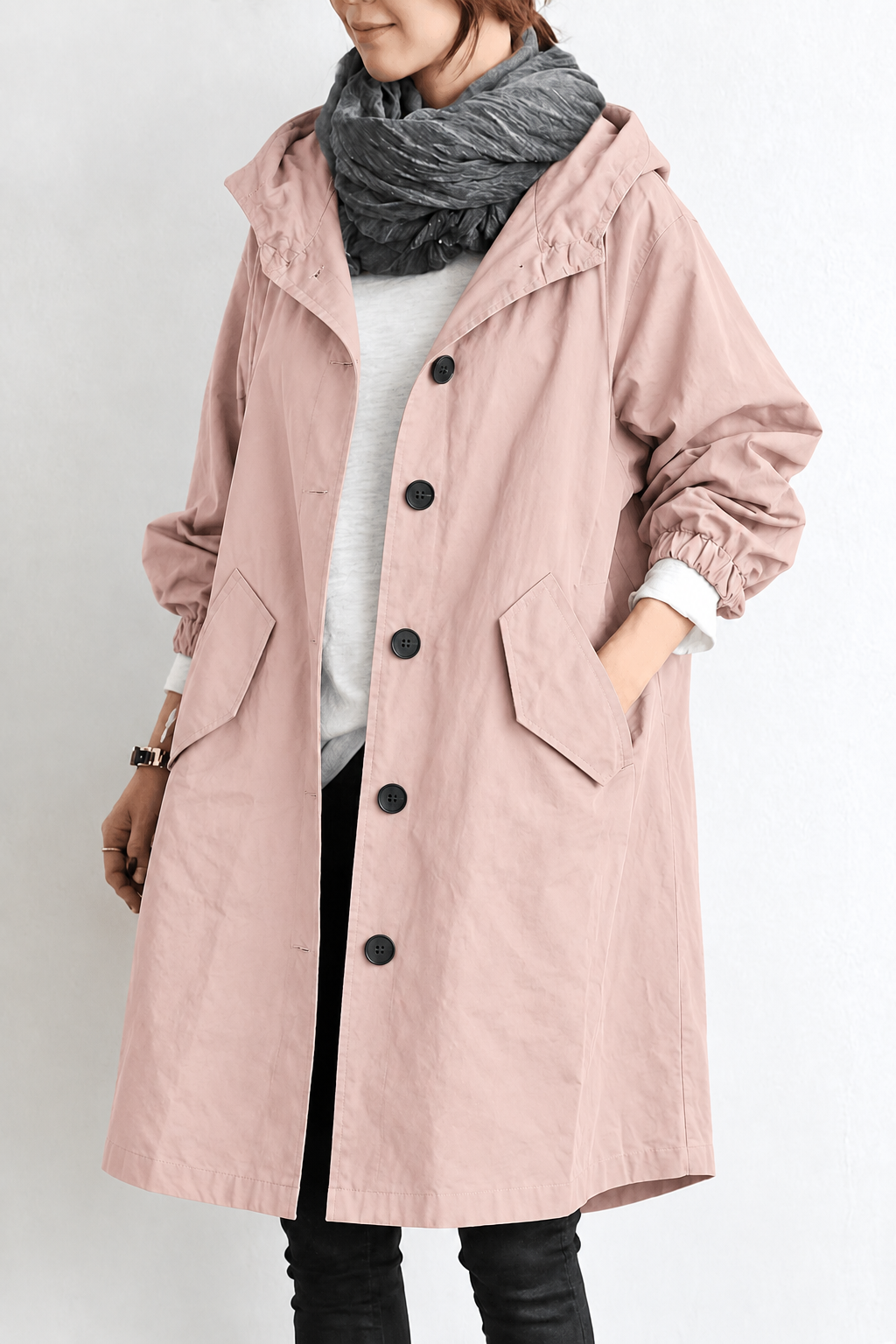 Woman wearing pink waterproof hooded rain trench coat