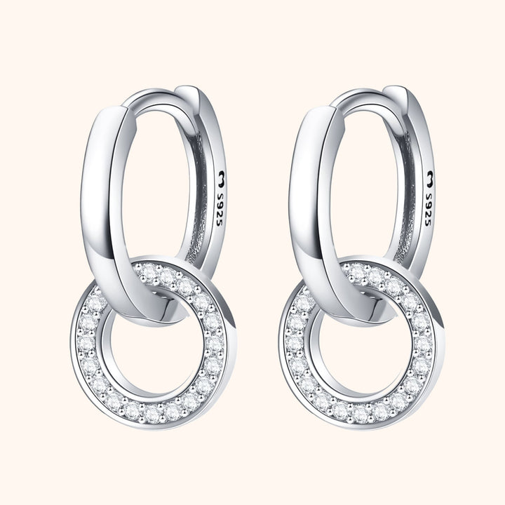 Close-up studio shot of silver linked circle hoop earrings on a light background