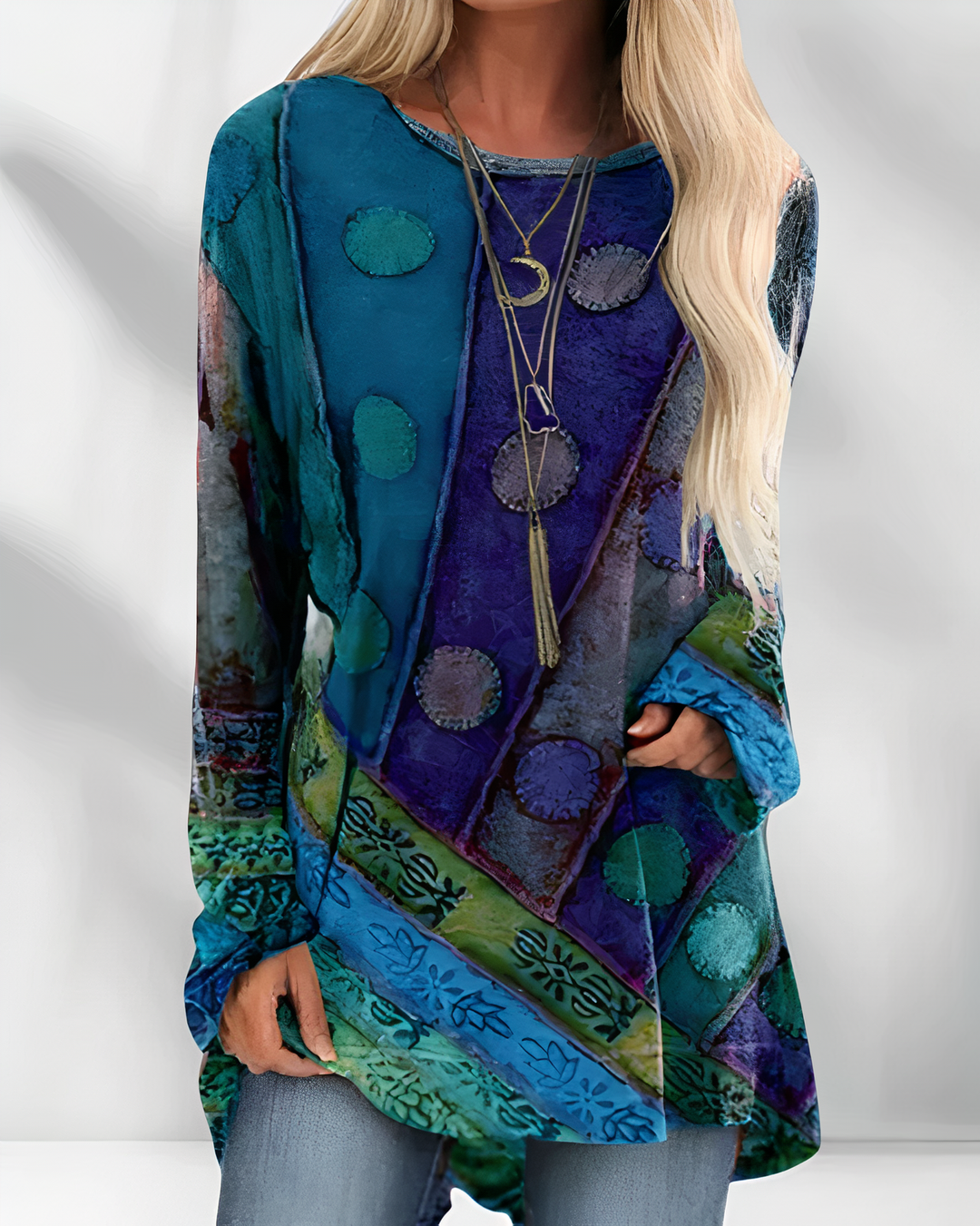 Woman wearing blue bohemian artistic print long sleeve tunic top with layered necklaces
