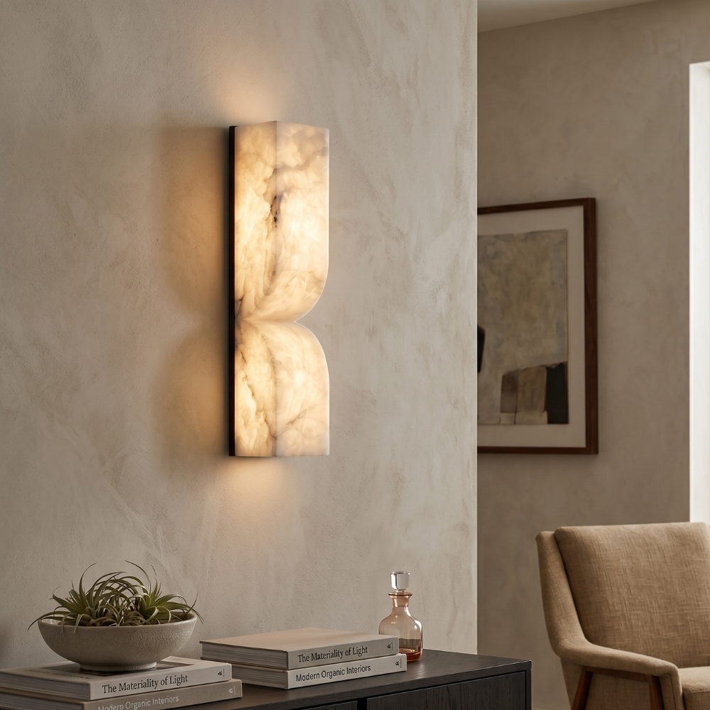 Close-up of a black and white alabaster wall lamp glowing softly above a dark console table.