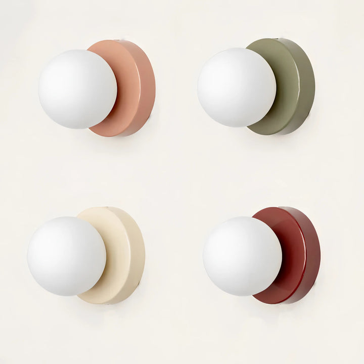 Collection of four modern glass wall lights featuring pink, green, white, and red circular bases