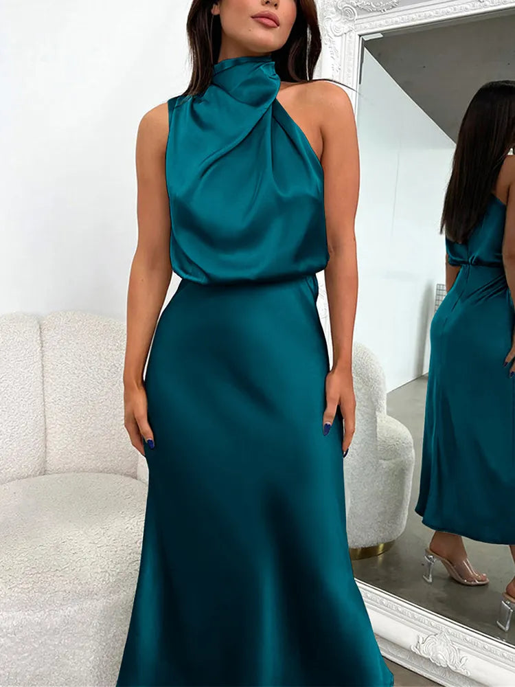 Woman wearing a dark green halter neck midi dress posing indoors