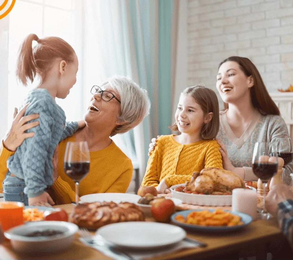 Happy senior woman enjoying a family dinner and conversation with her grandchildren