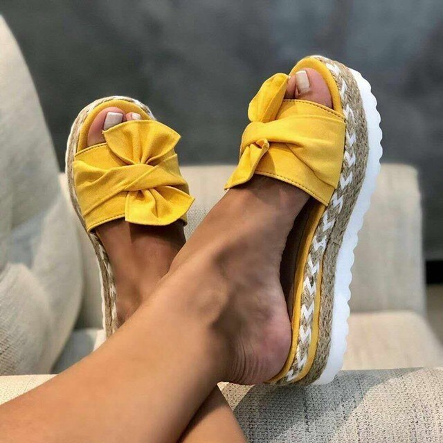 Side angle of women's elegant bow woven wedge sandals showing platform heel