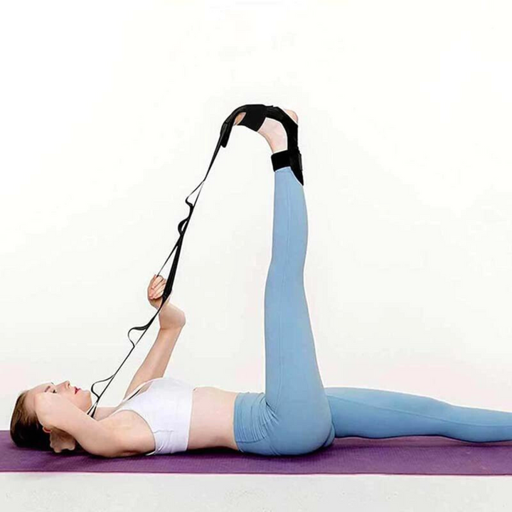 Woman lying on exercise mat using a black fascia leg stretcher strap [[lstfy-media:1]]