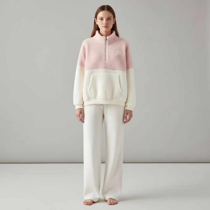 Full-body view of a model in a pink fleece pullover and white wide-leg trousers