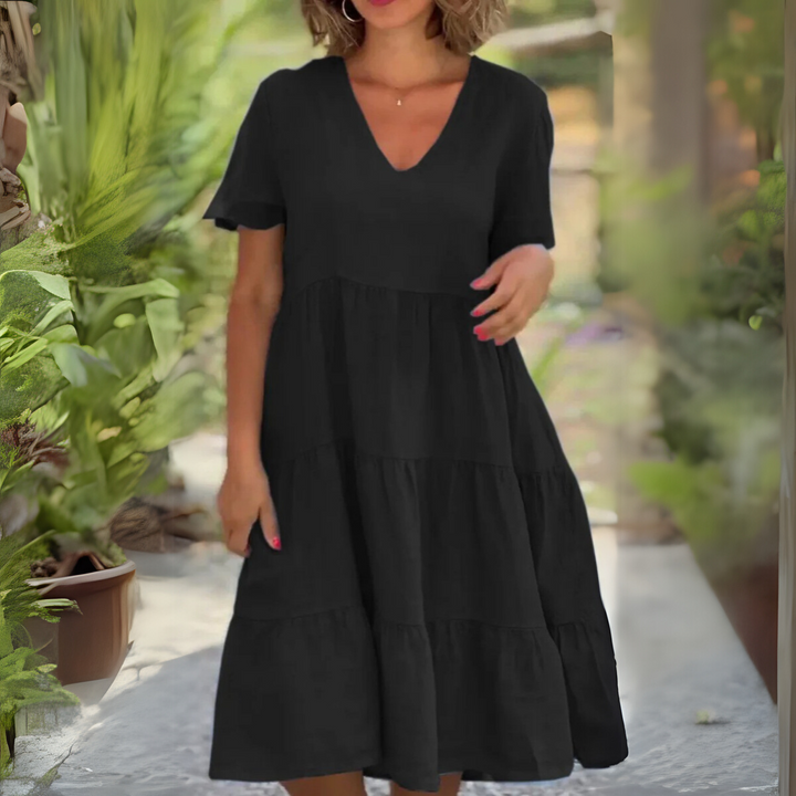 Woman wearing a classic black short sleeve V-neck midi dress