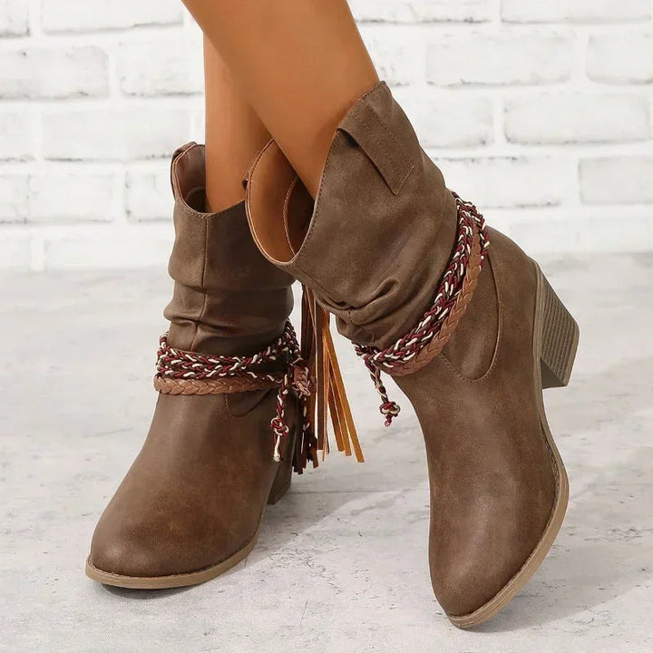 Close-up of women wearing dark brown western boots with braided tassel details