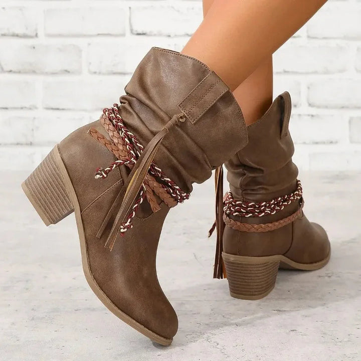 Angle view showcasing the decorative tassels and braided strap accents on boots