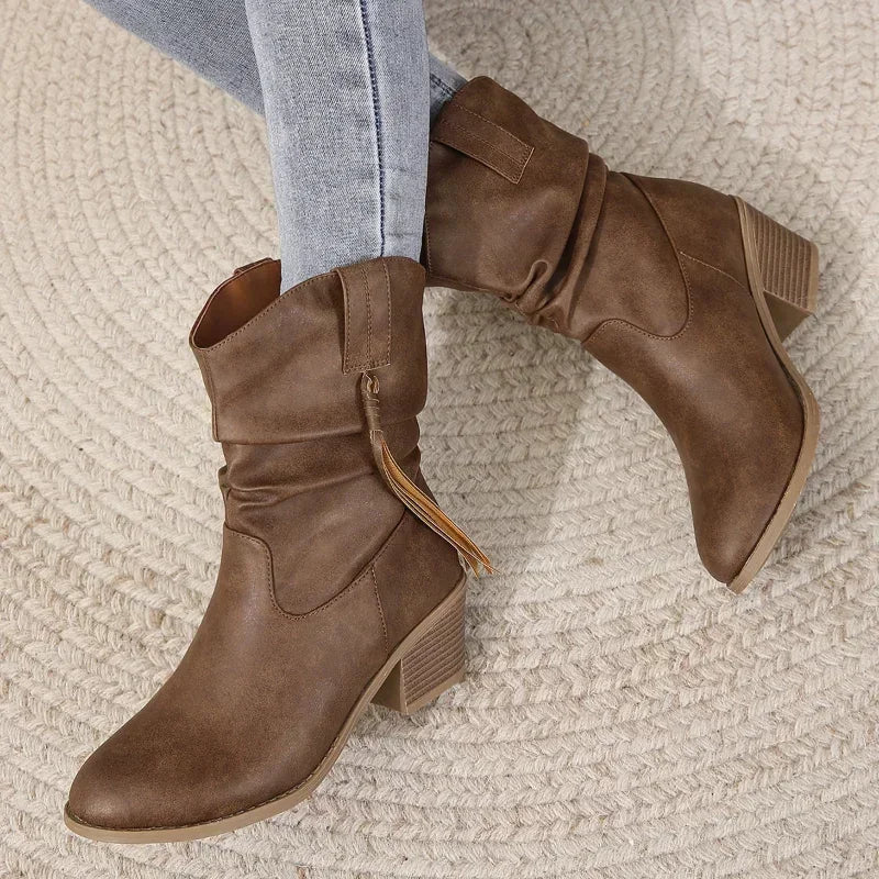 Close-up of stylish tassel and braided strap on brown western boots