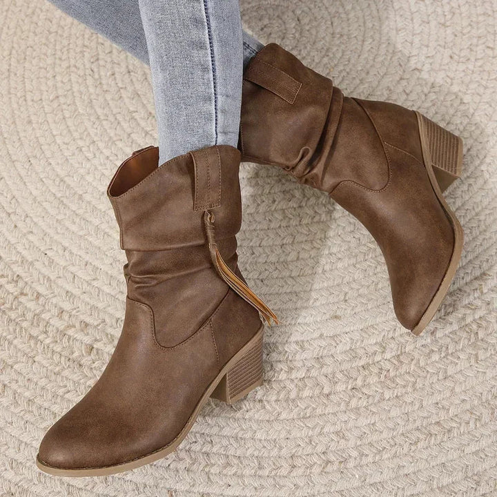 Close-up of stylish tassel and braided strap on brown western boots