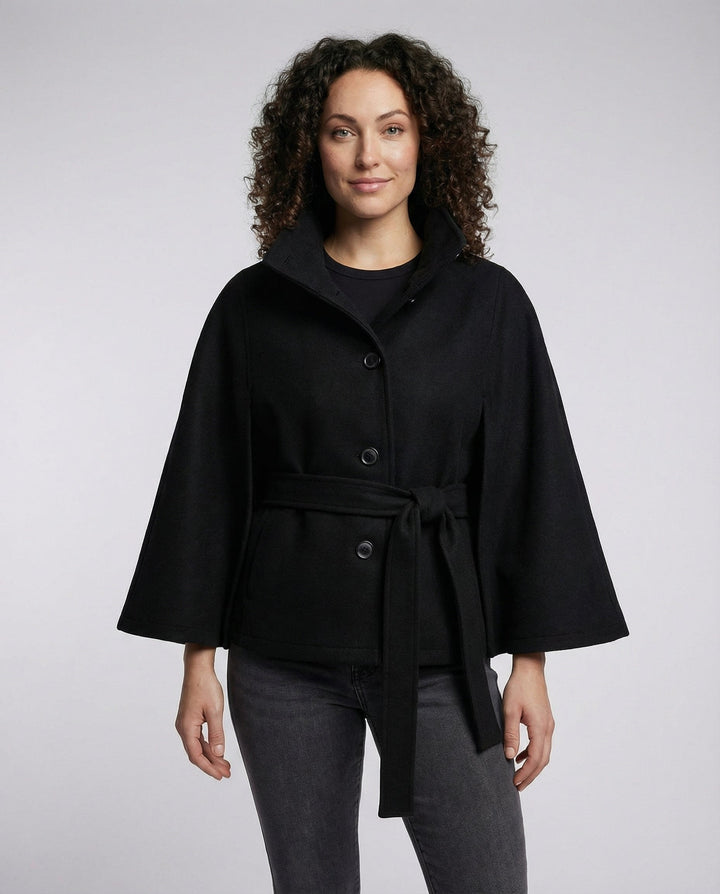 Model wearing black high-collar belted wrap jacket with curly hair