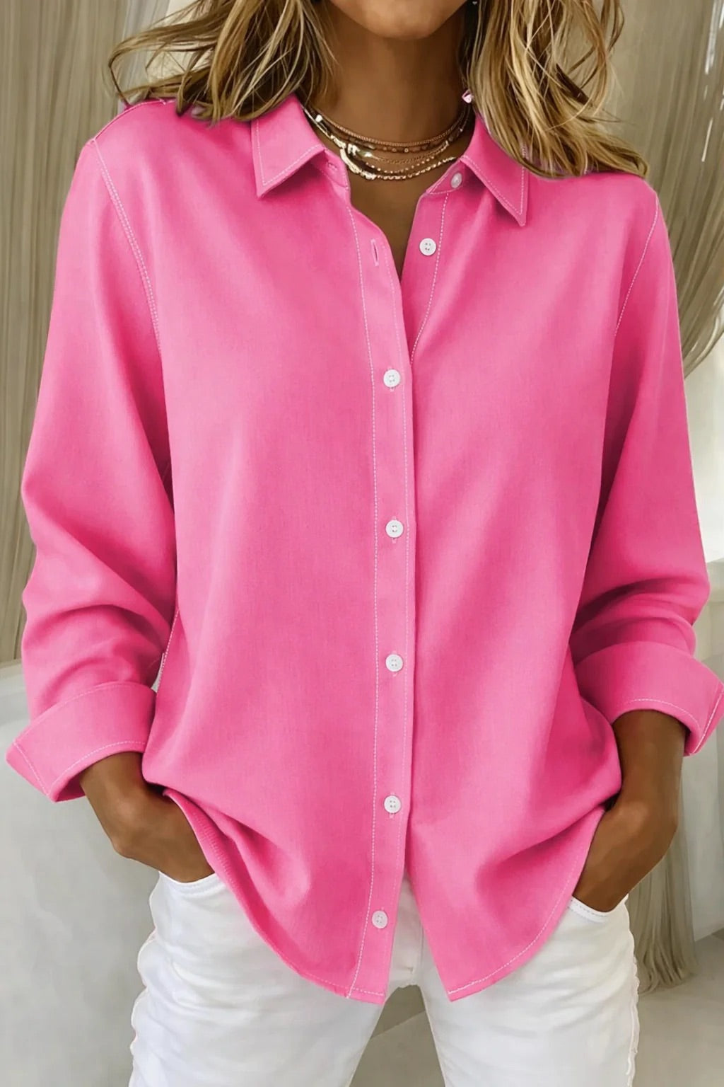 Woman wearing vibrant fuchsia button-front blouse with classic collar