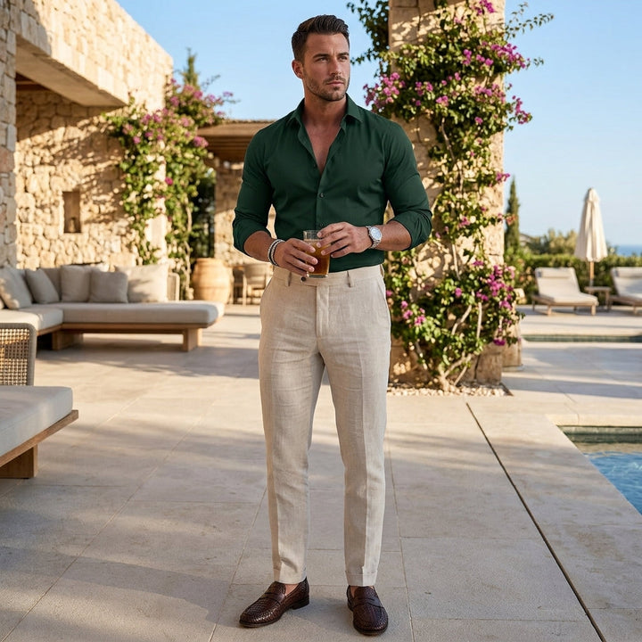 Man wearing a dark green button-up shirt outdoors with beige trousers