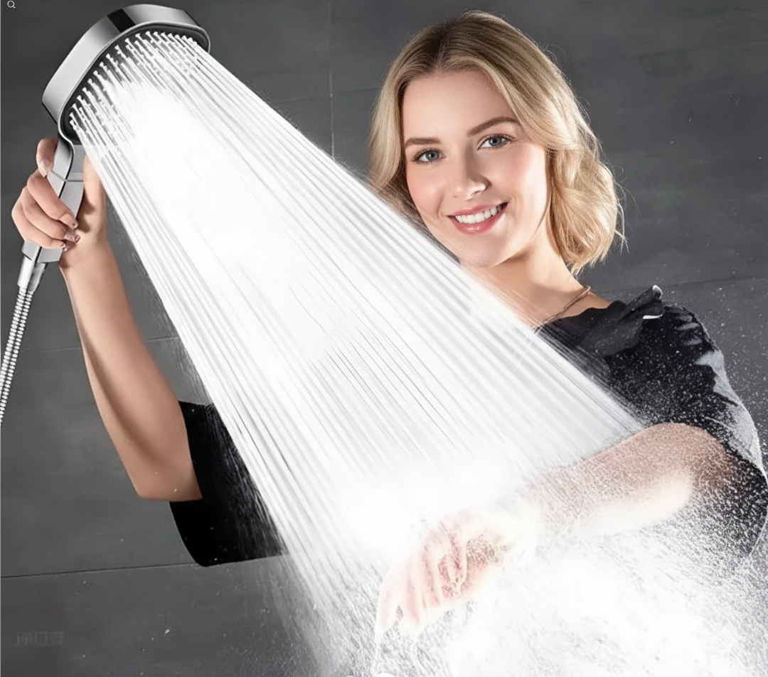 Woman smiling while holding a shiny silver high-pressure shower head with active water spray