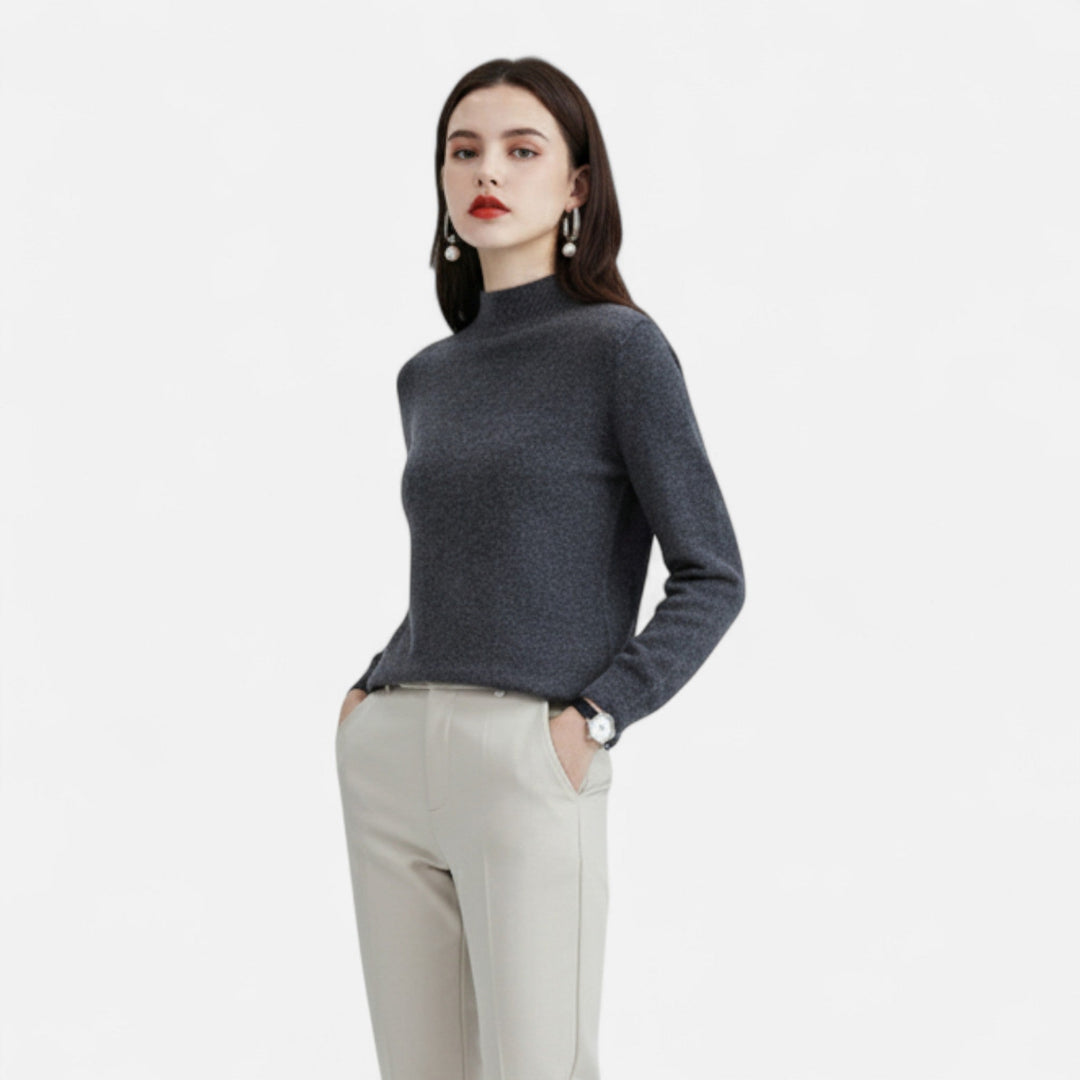 Model wearing women's dark grey mock neck sweater with light trousers