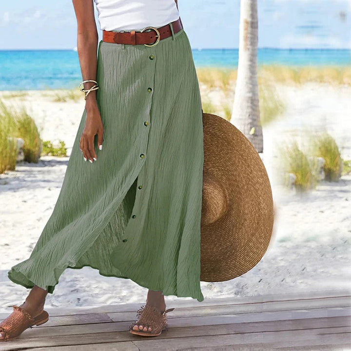 Woman wearing green A-line button midi skirt near tropical scenery
