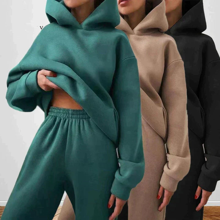 Three women posing in matching jogging sets in different colors