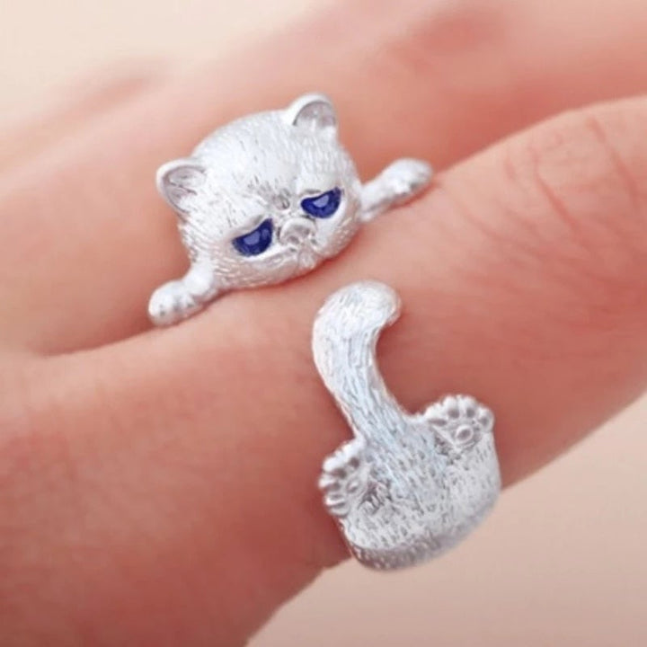 Close-up view of the adjustable silver cat ring worn on a finger