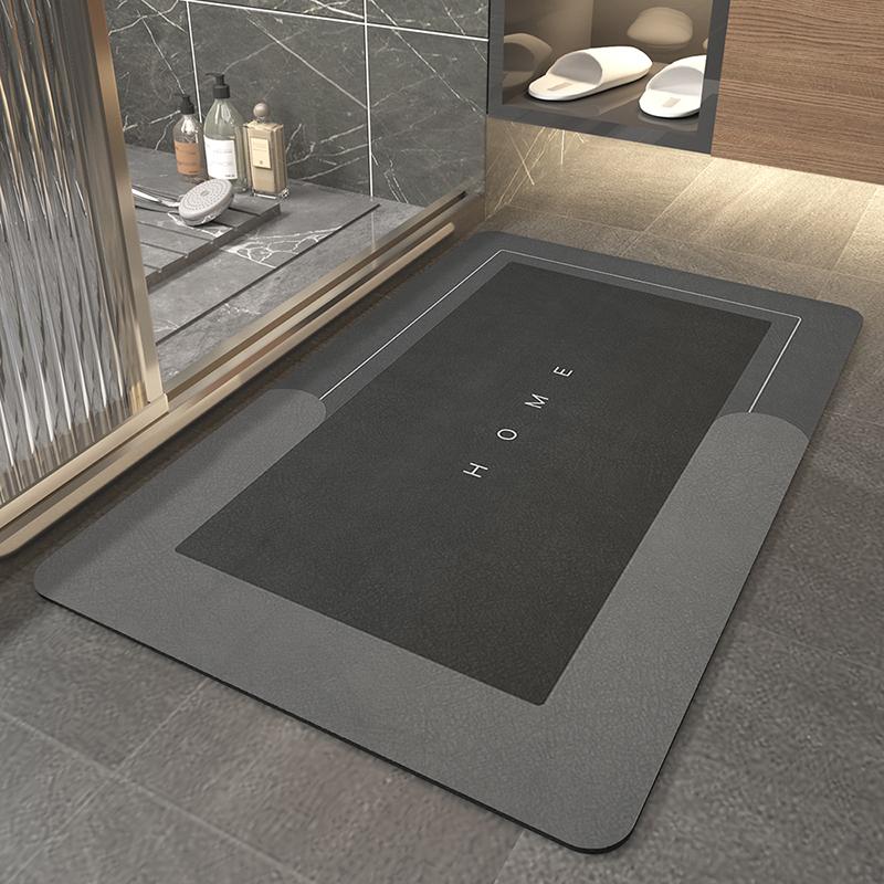 Rectangular quick-dry stone bath mat in black and grey placed on a tiled bathroom floor