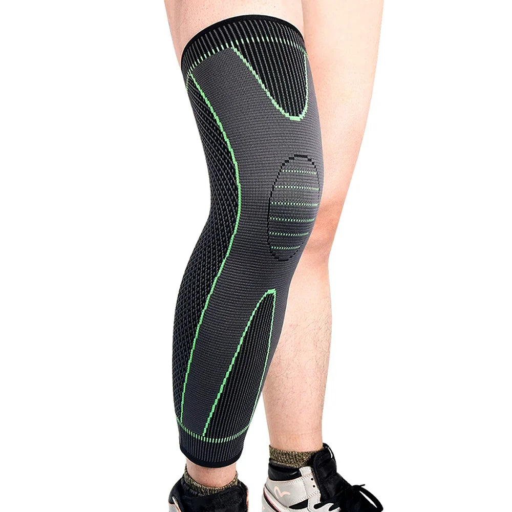 Close-up of a person wearing a grey and green knee compression sleeve on the leg.