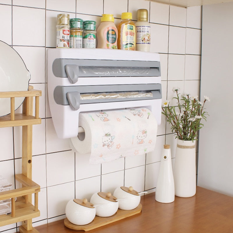 Kitchen foil and paper towel organizer mounted on a tiled wall with condiment bottles on top