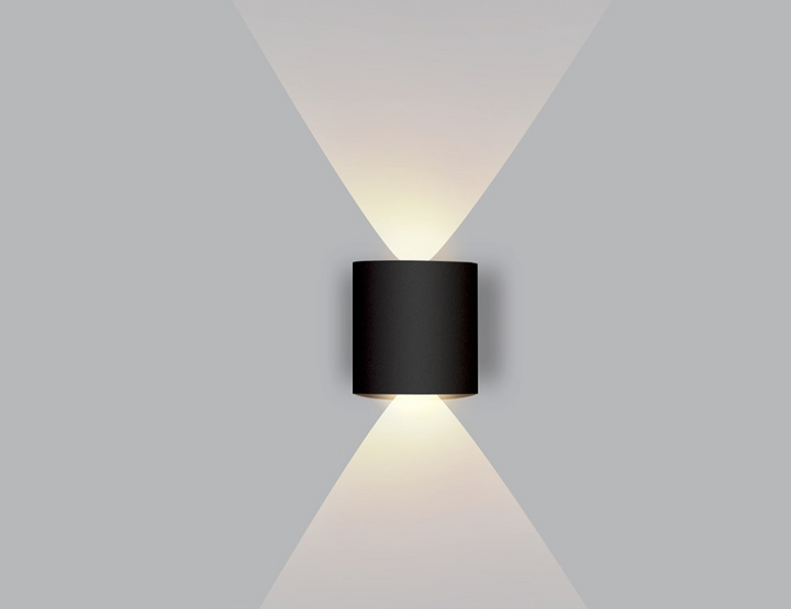 Dual beam LED wall sconce casting bright light upward and downward in a hallway.