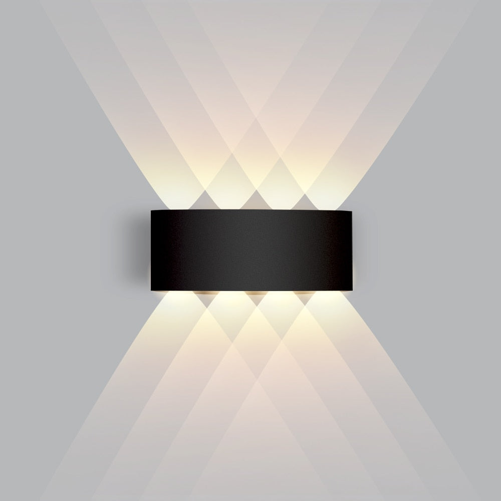 Black modern LED wall lamp mounted on a grey wall with symmetric light beams