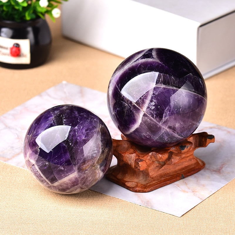 Polished natural amethyst gemstone sphere showing deep purple crystal patterns for home decor.