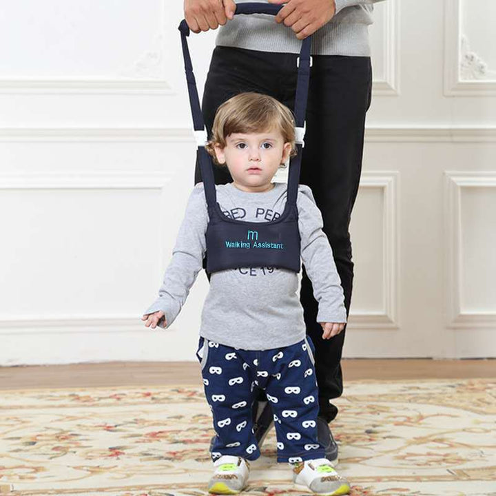 Toddler walking happily using the safety harness assisted by a parent