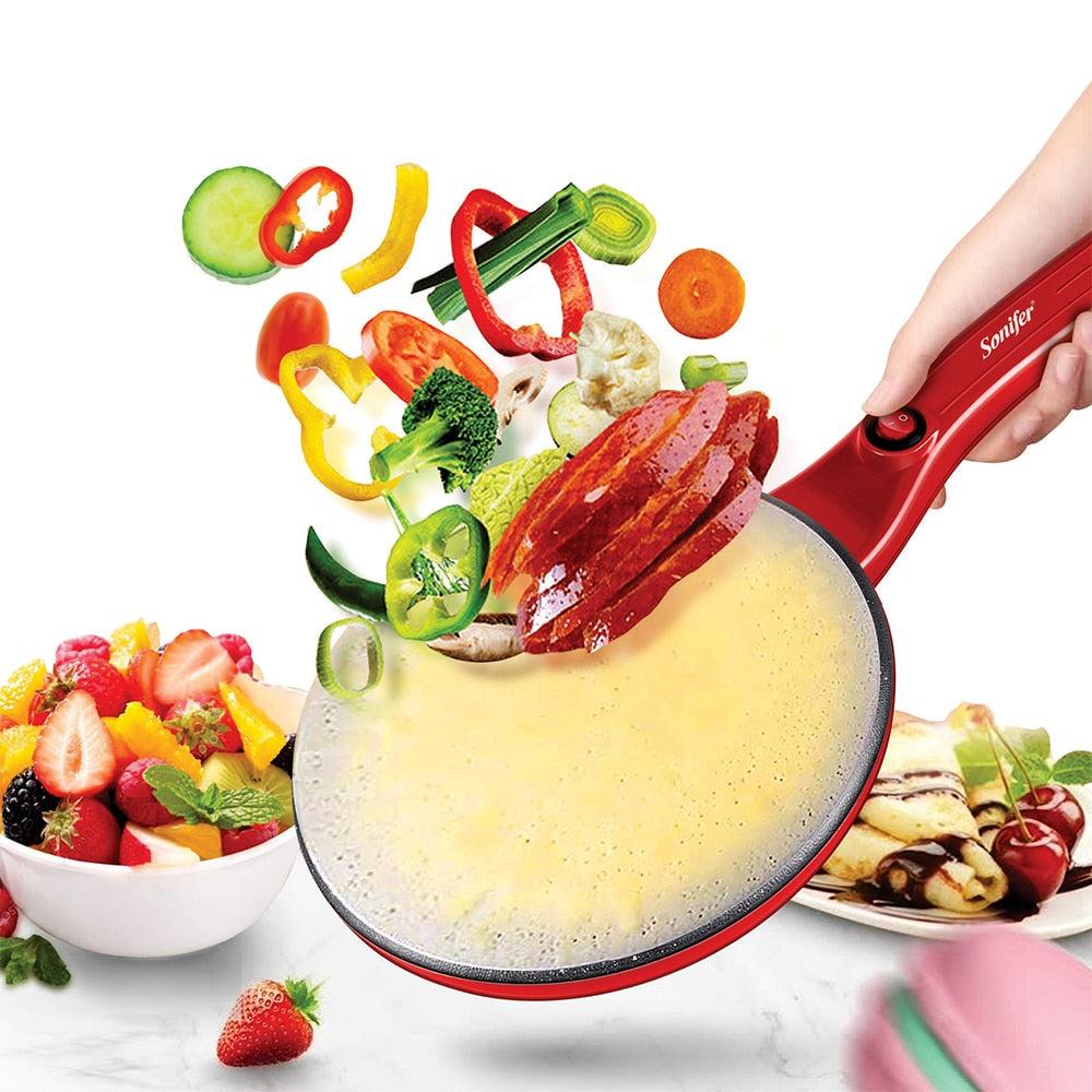 Electric crepe maker in red with fresh fruits and ingredients