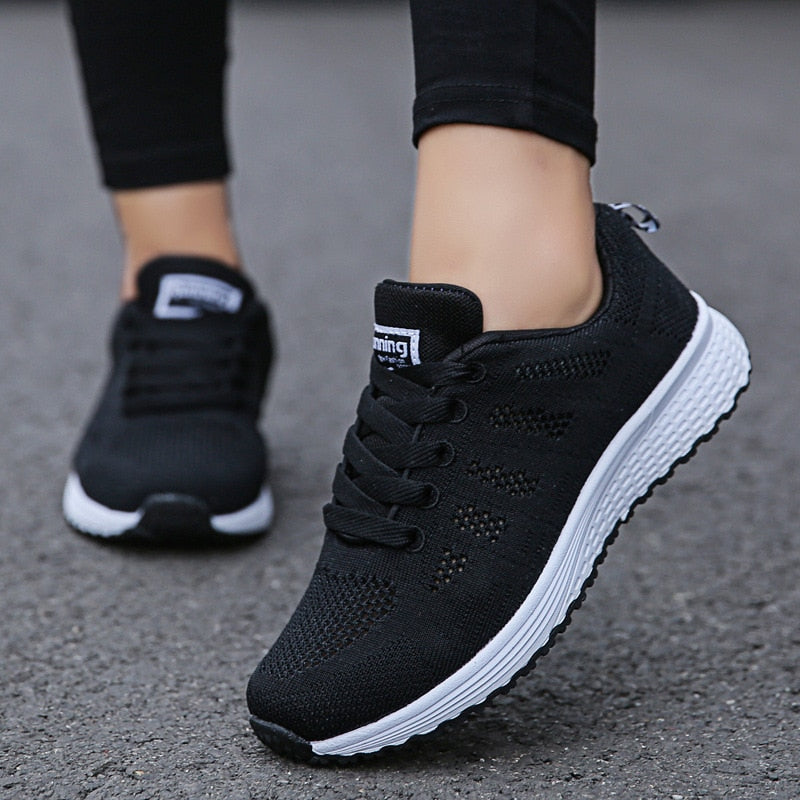 Close-up of black slip-resistant sneakers worn outdoors on pavement
