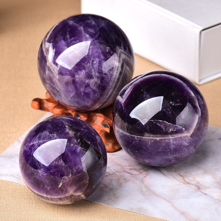 Angle view of glossy purple amethyst gemstone globes displaying natural mineral patterns