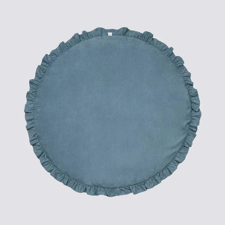 Child playing with toys on the comfortable round nursery mat