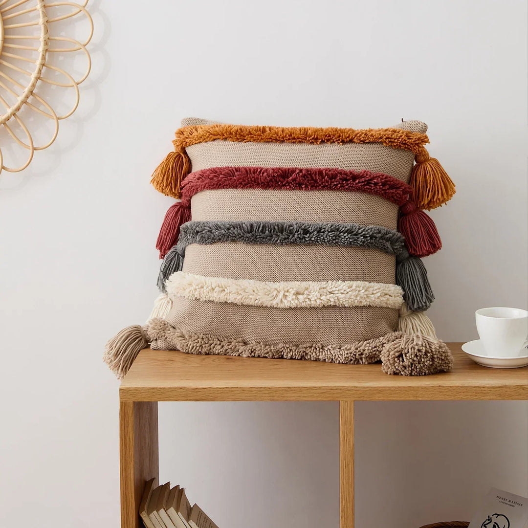 Close-up of decorative striped pillow cover showing woven fabric and fringe detail