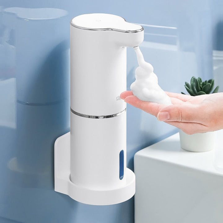 Automatic foaming soap dispenser mounted on a wall with a custom holder dispensing foam