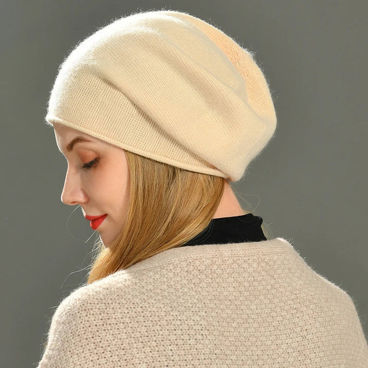 Close-up view of a woman in an elegant cream-colored soft knit beanie hat for winter