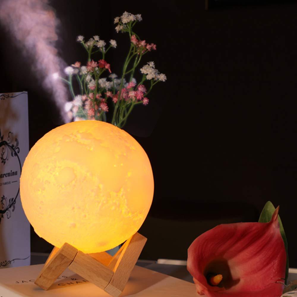 Mist rising from the textured moon lamp and air humidifier on a wooden table