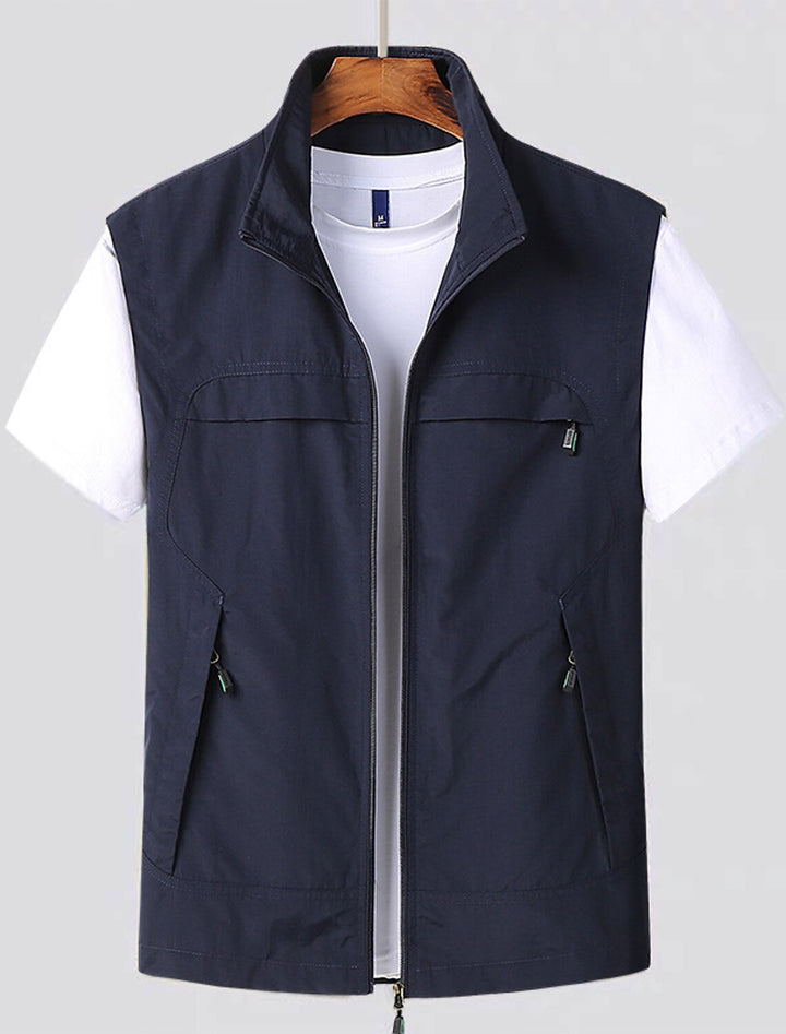 Men's navy blue water-repellent zip utility vest hanging on a display