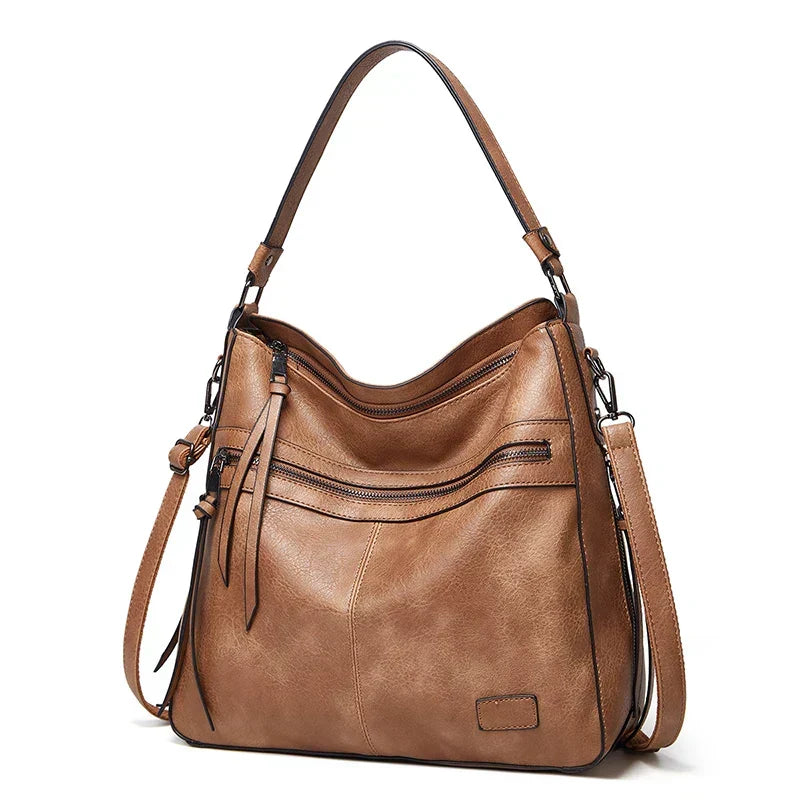 Front view of the brown shoulder bag displaying detailed craftsmanship and hardware