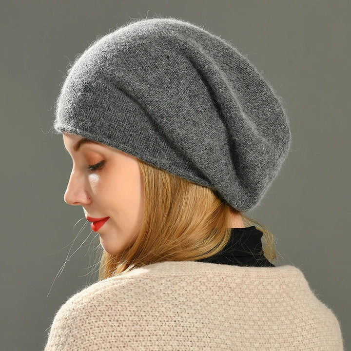 Woman modeling a stylish gray knit beanie hat with a minimalist design in cold weather